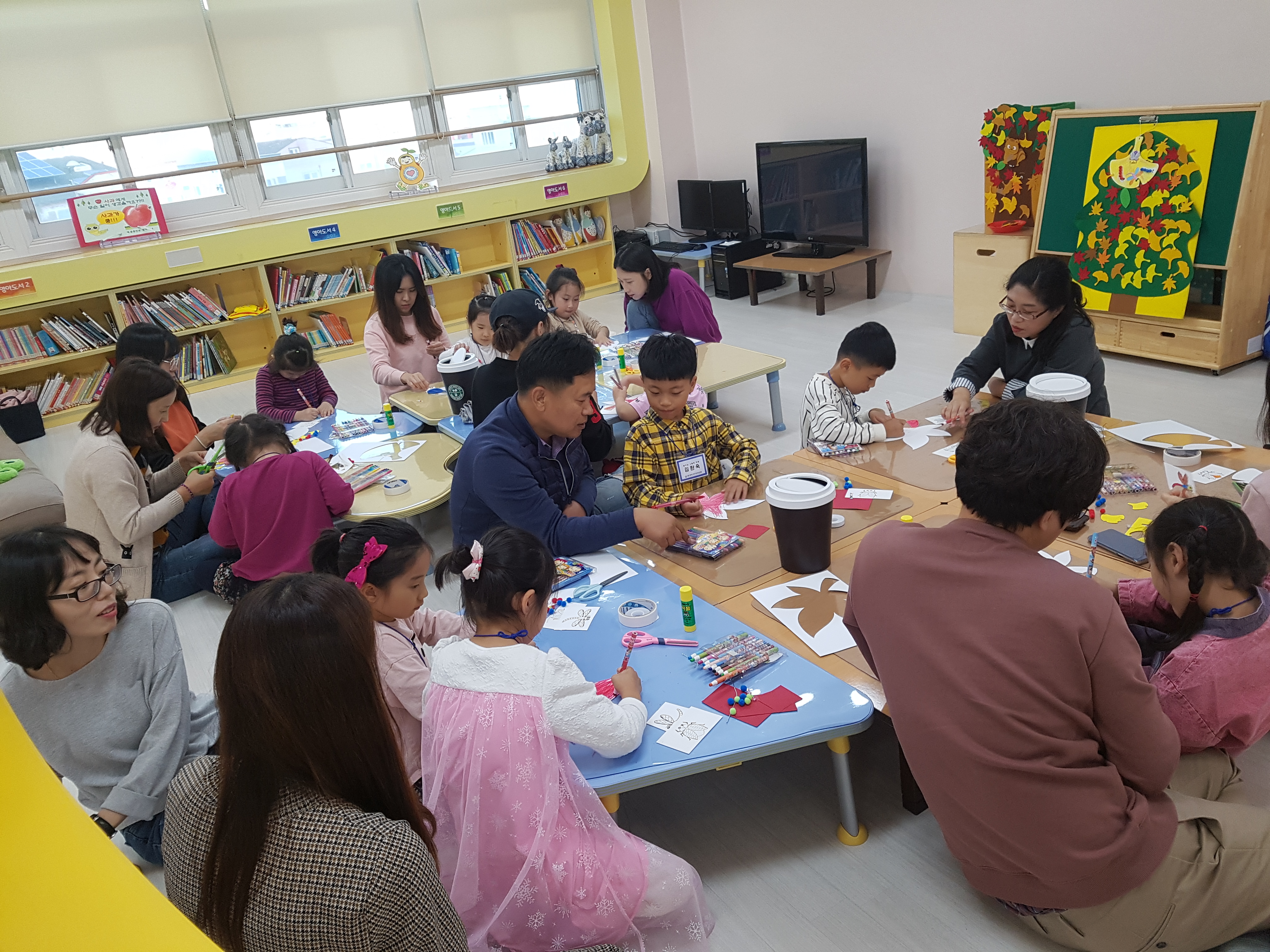 부모와함께 종이를 오리는 유아들