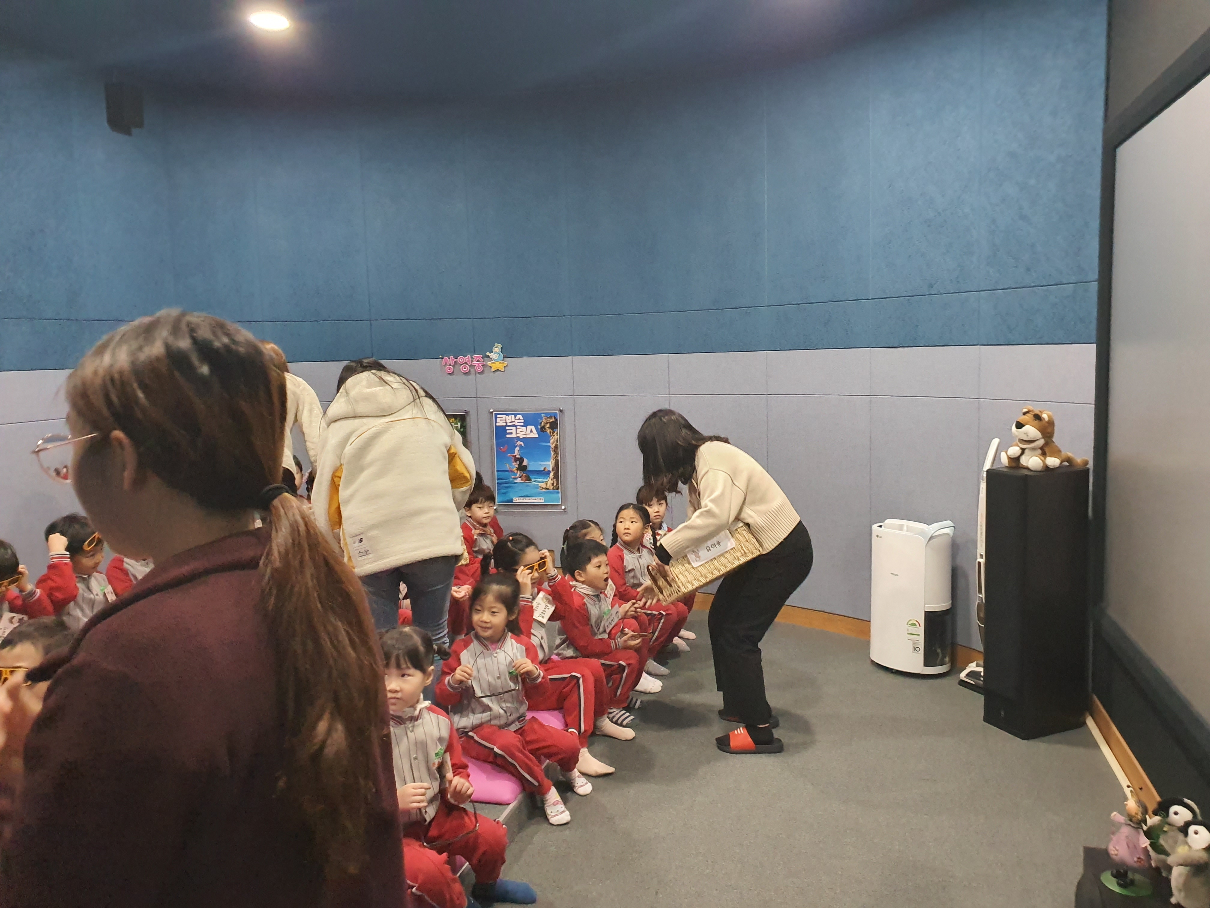 체험도구를 배부하는 여고생들과 배부받기위해 대기하고있는 유아들